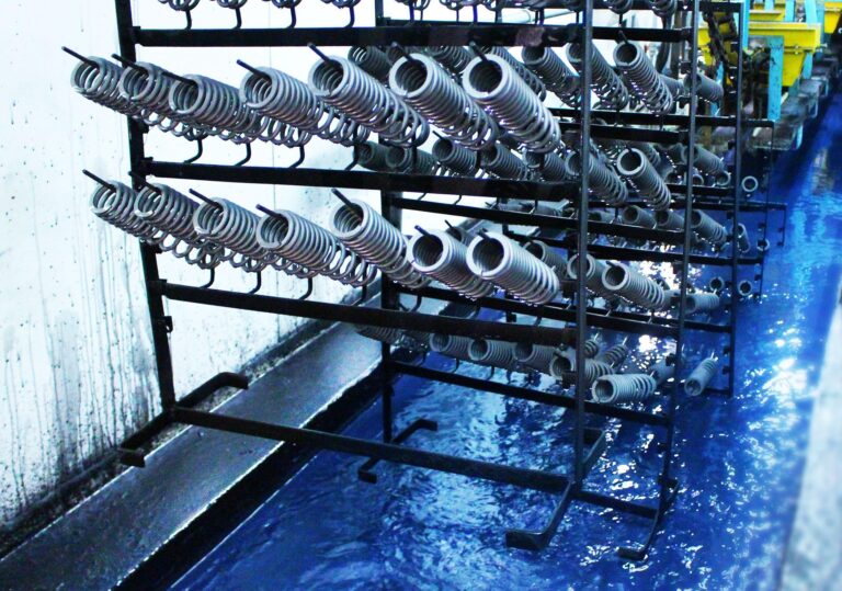 Parts on racks in a phosphating tank